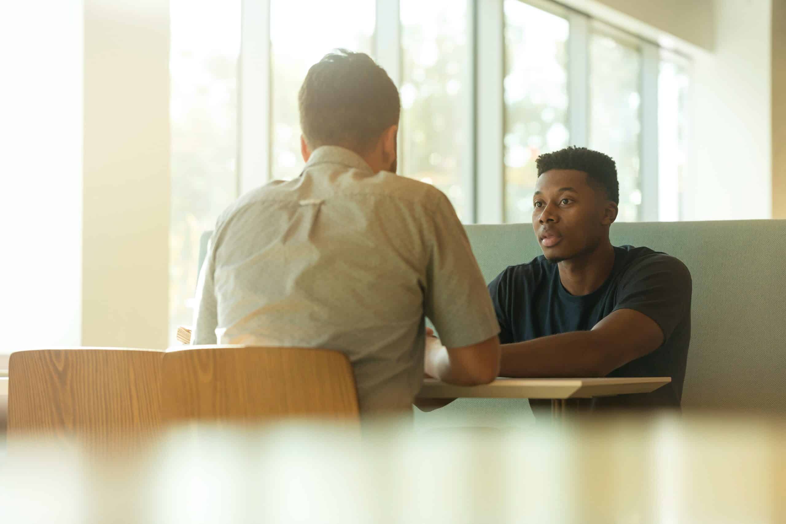Two men having a conversation at a table