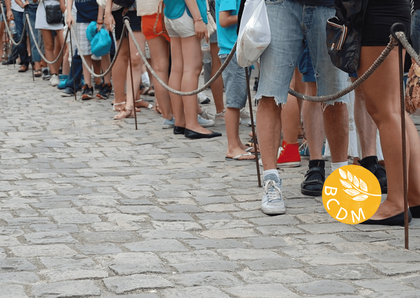 image showing the legs and feet of people in a queue