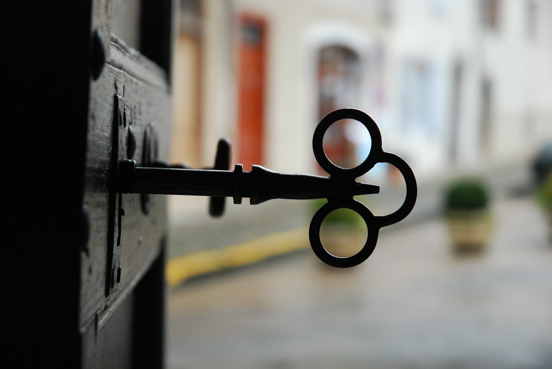 an old metal key in an open wooden door